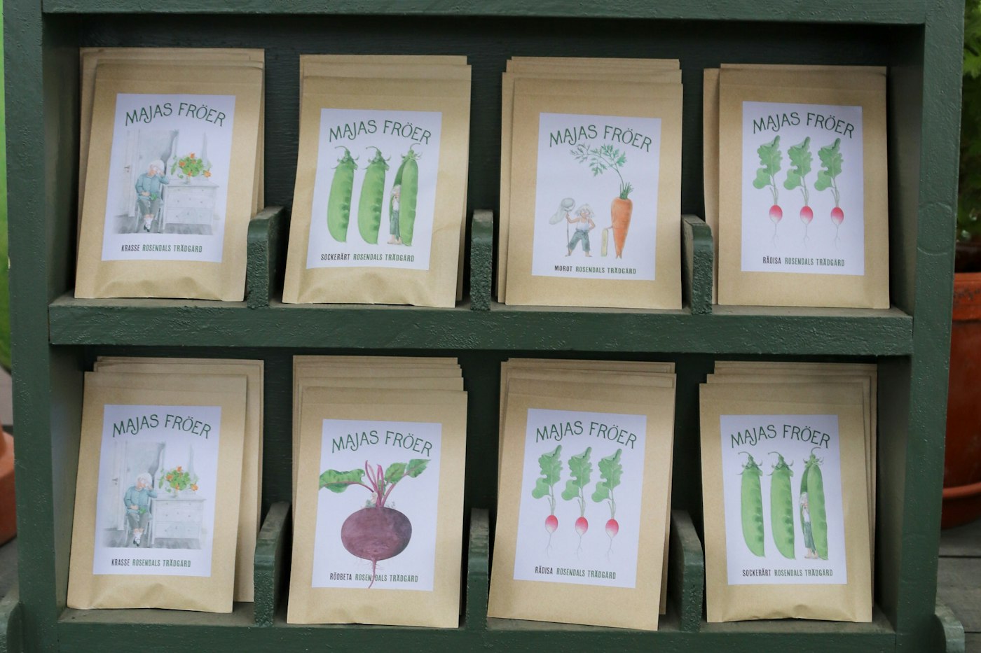 Seed packets displayed on a wooden shelf